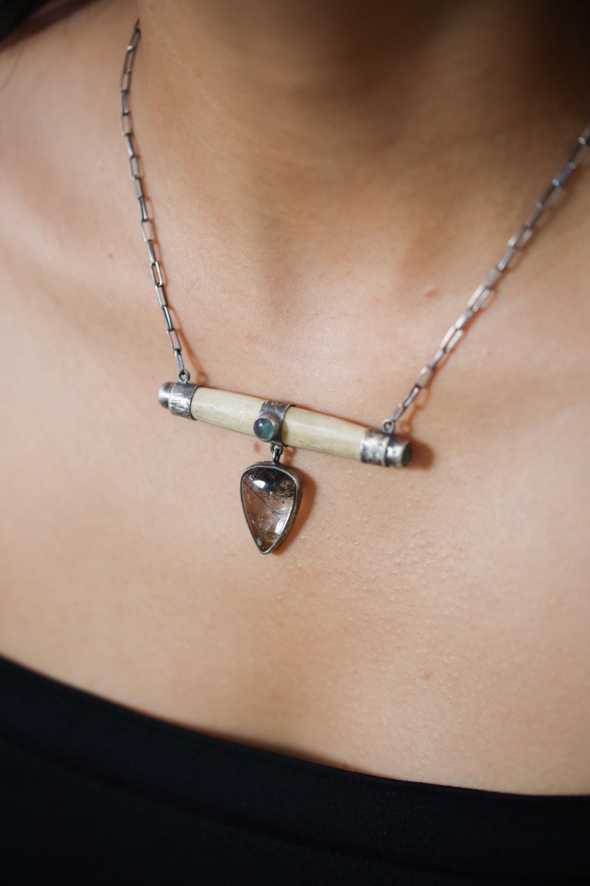 Aquamarine Bone Black Rutile Quartz necklace shown worn on the chest, with oxidized 925 sterling silver and horizontal pendant design.