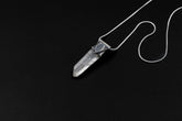 Water Clear Nepalese Inclusion Quartz Pendant shown on black background with oxidized sterling silver cap and black cotton necklace.