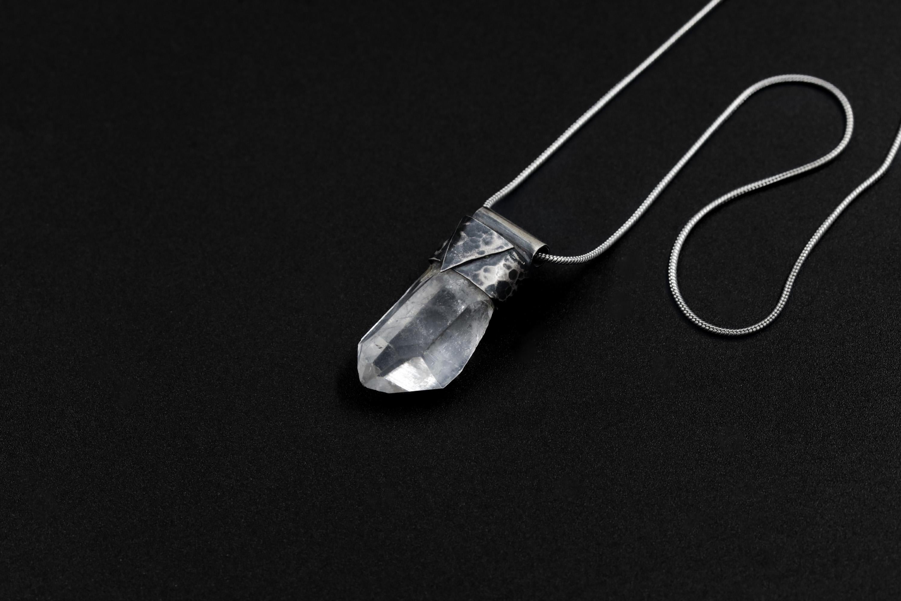 Water Clear Nepalese Inclusion Quartz Pendant shown on black background with oxidized sterling silver cap and black cotton necklace.