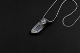 Water Clear Nepalese Inclusion Quartz Stack Pendant shown on black background with oxidized sterling silver cap and black cotton necklace.