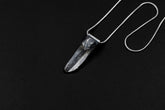 Water Clear Nepalese Inclusion Quartz pendant shown on a black background with oxidized sterling silver cap and black cotton necklace.