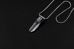 Water Clear Nepalese Inclusion Quartz pendant shown on a black background with oxidized sterling silver cap and black cotton necklace.
