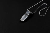 Water Clear Nepalese Inclusion Quartz Pendant shown on black background with oxidized sterling silver cap and black cotton necklace.