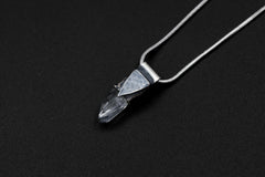 Water Clear Nepalese Inclusion Quartz pendant shown on black background with oxidized sterling silver cap and black cotton necklace.
