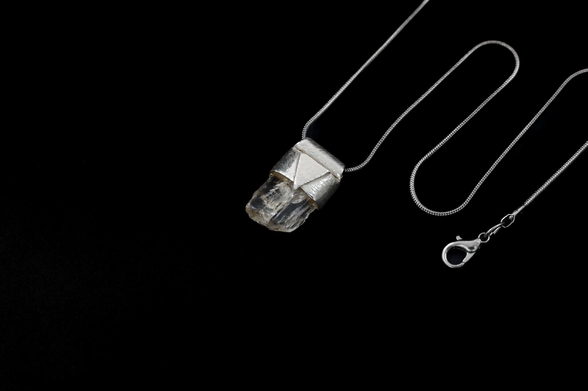 Clear Rainbow Inclusion Spodumene Stack Pendant shown on black background with adjustable black cotton necklace and silver cap.