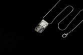 Clear Rainbow Inclusion Spodumene Stack Pendant shown on black background with adjustable black cotton necklace and silver cap.