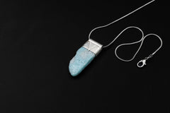 Freeform Larimar Stack Pendant shown on black background with adjustable black cotton necklace and organic silver cap.