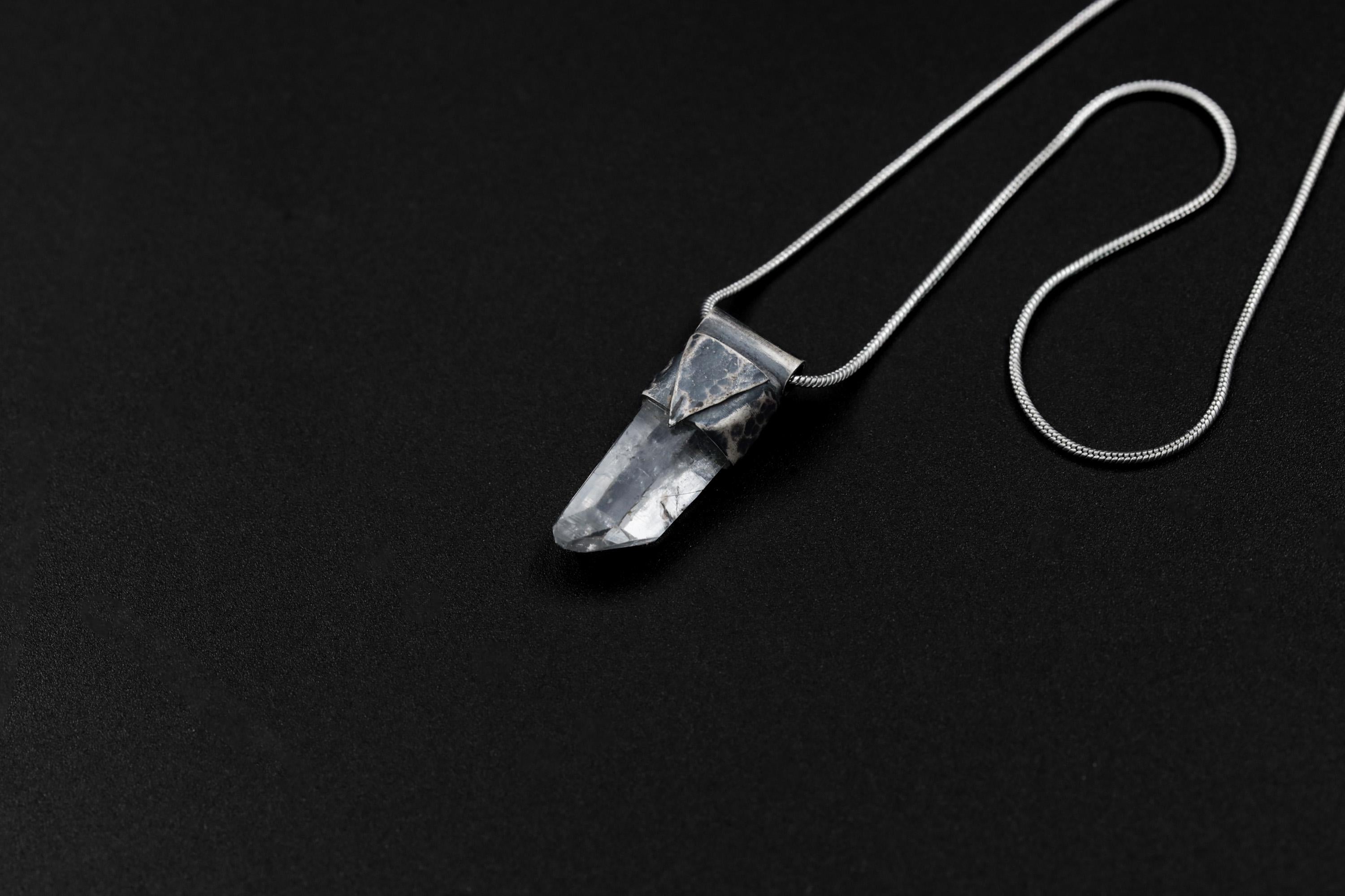 Water Clear Nepalese Inclusion Quartz Pendant shown on black background with oxidized sterling silver cap and black cotton necklace.