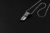 Water Clear Nepalese Inclusion Quartz Pendant shown on black background with oxidized sterling silver cap and black cotton necklace.