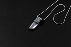 Water Clear Nepalese Inclusion Quartz Pendant shown on black background with oxidized sterling silver cap and black cotton necklace.