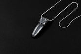 Water Clear Nepalese Inclusion Quartz Pendant shown on black background with oxidized sterling silver cap and black cotton necklace.