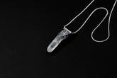 Water Clear Nepalese Inclusion Quartz pendant shown on black background with oxidized sterling silver cap and black cotton necklace.