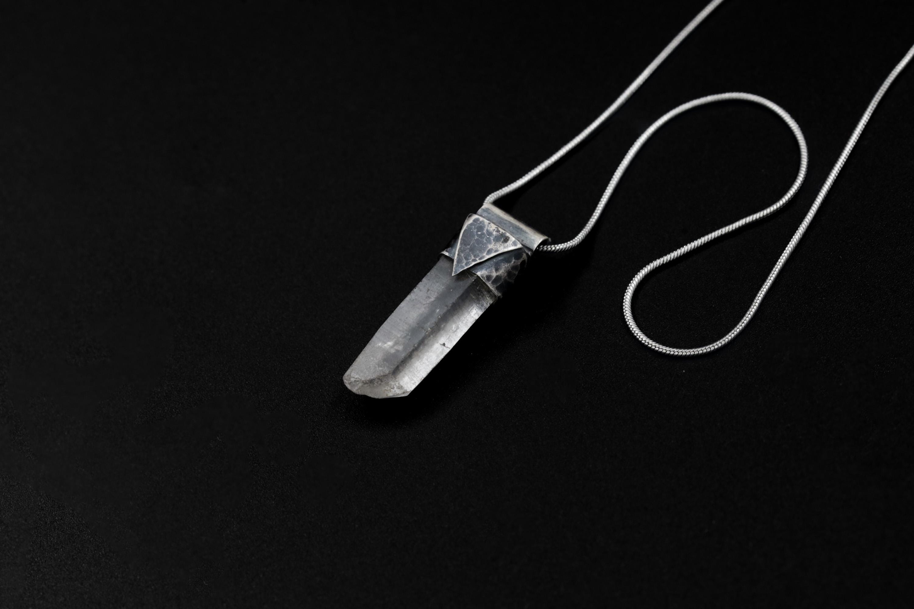 Water Clear Nepalese Inclusion Quartz pendant shown on black background with oxidized sterling silver cap and black cotton necklace.