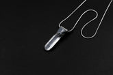 Water Clear Nepalese Inclusion Quartz pendant shown on black background with oxidized sterling silver cap and black cotton necklace.