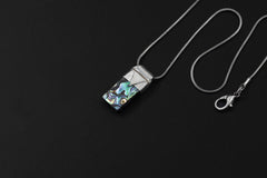 Mother of Pearl Stack Pendant shown on black background with adjustable black cotton necklace and sterling silver cap.
