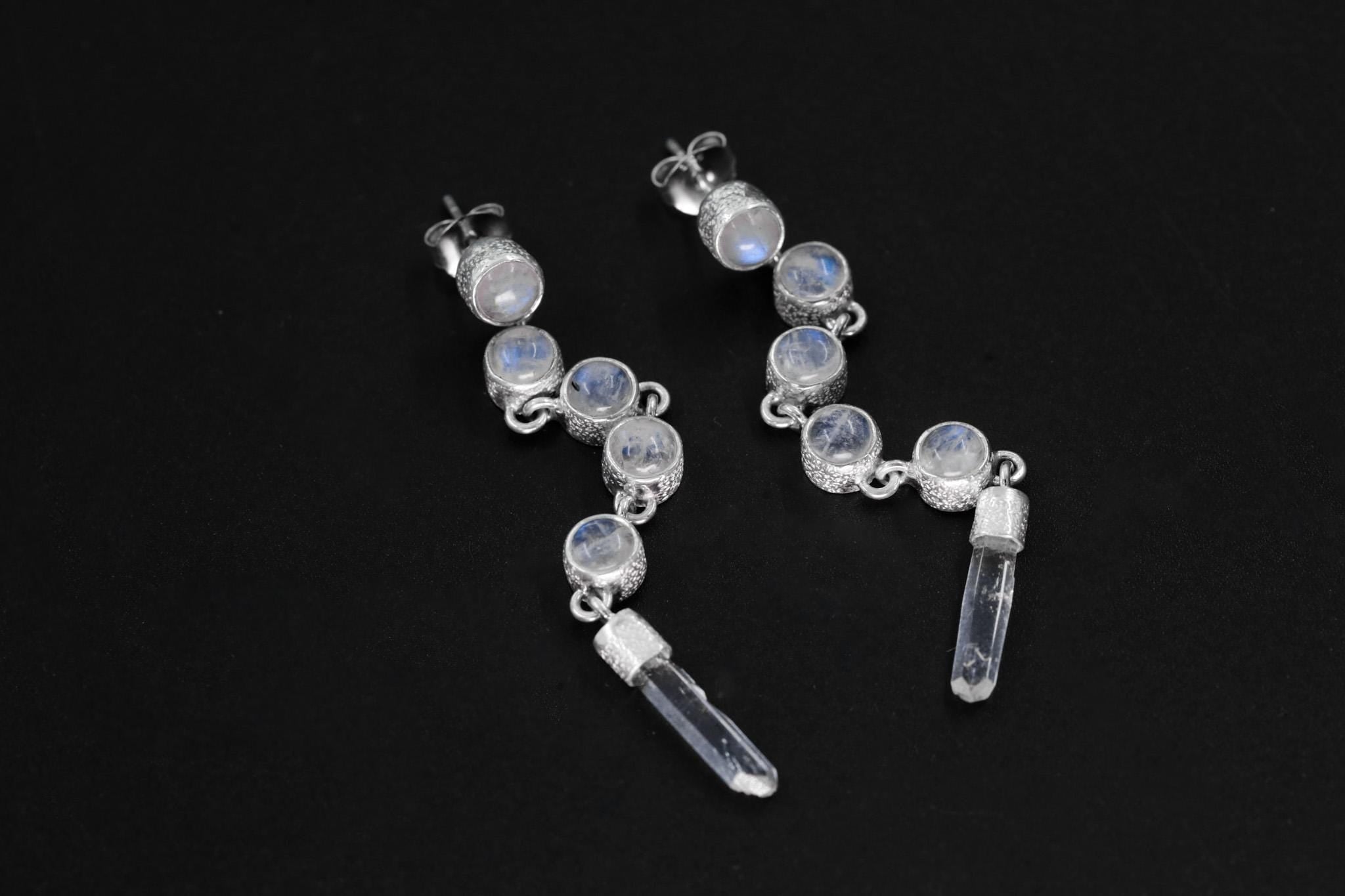 Blue Moonstone and Clear Quartz sterling silver cascade earrings shown on dark background with long crystal drops.