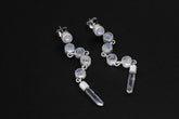 Blue Moonstone and Clear Quartz sterling silver cascade earrings shown on dark background with long crystal drops.