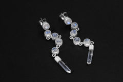 Blue Moonstone and Clear Quartz sterling silver cascade earrings shown on dark background with long crystal drops.