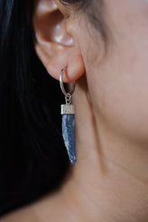 Blue Kyanite single hoop earring in 925 sterling silver shown worn on the ear with a slim blue crystal drop.