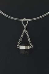 Black Tourmaline pendant displayed on choker against dark background as a Root Chakra talisman.