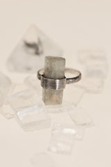 Raw Aquamarine ring displayed on crystal styling with hammered sterling silver band and brushed setting.