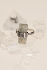 Raw Aquamarine ring displayed on crystal styling with hammered sterling silver band and brushed setting.