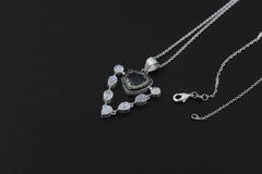 Green Tourmaline Moonstone halo pendant shown worn as a luminous sterling silver necklace with organic textured detail.