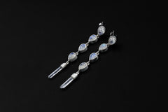 Blue Moonstone and Clear Quartz sterling silver earrings shown on a dark background, with teardrop stones and raw crystal points.