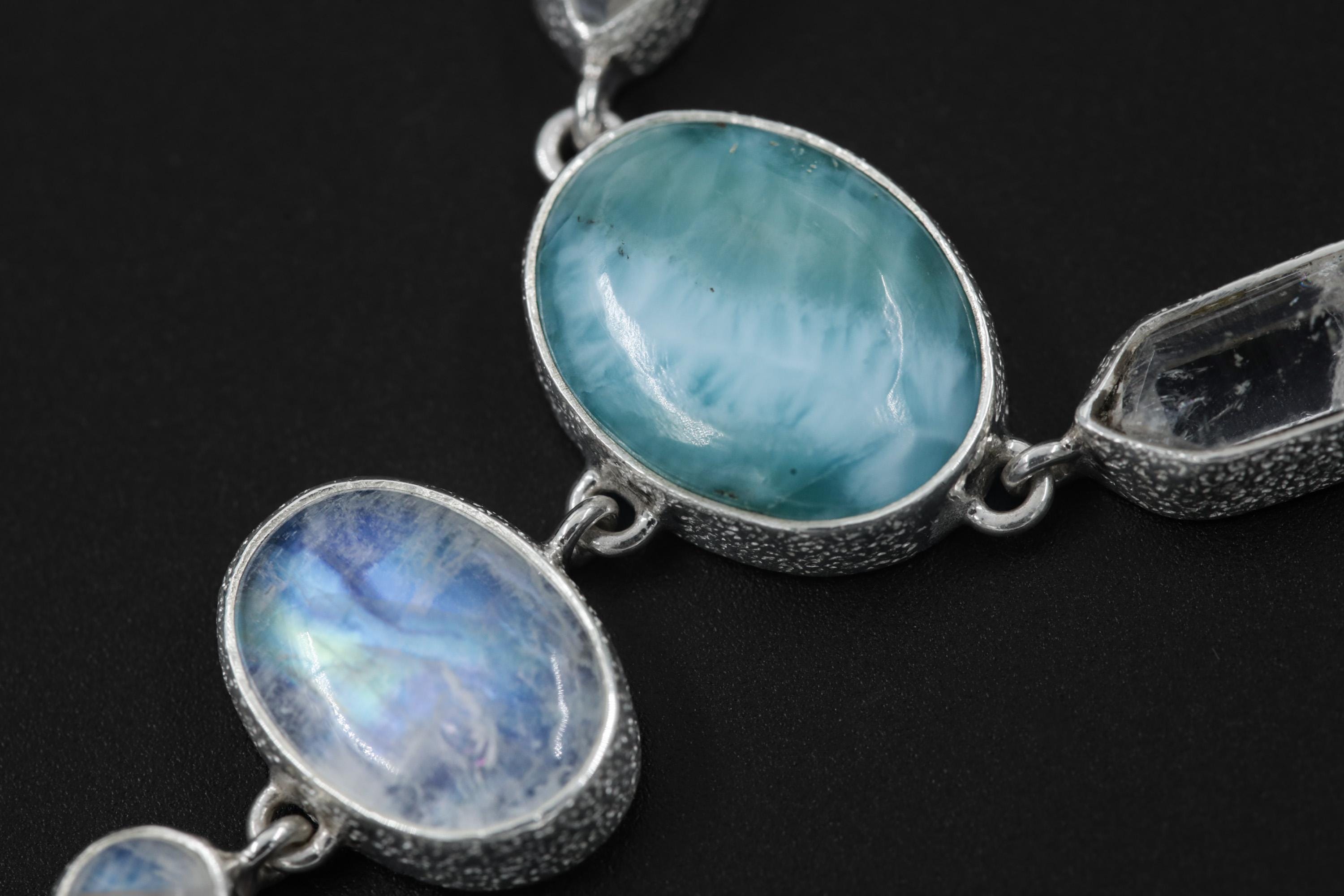 Close-up of Blue Moonstone and Larimar stones in a sterling silver necklace, showing lunar glow and ocean-blue colour.