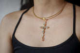 Petroleum Smoky Quartz cross pendant shown worn on the chest, with 18k gold-plated sterling silver and raw smoky stones.
