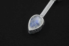 Close-up of Blue Moonstone teardrop in a high-polish sterling silver cosmic talisman pendant.