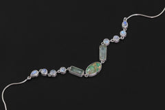 Celestial River necklace shown on a dark background with flowing Turquoise, Aquamarine, and Rainbow Moonstone gemstone layout.
