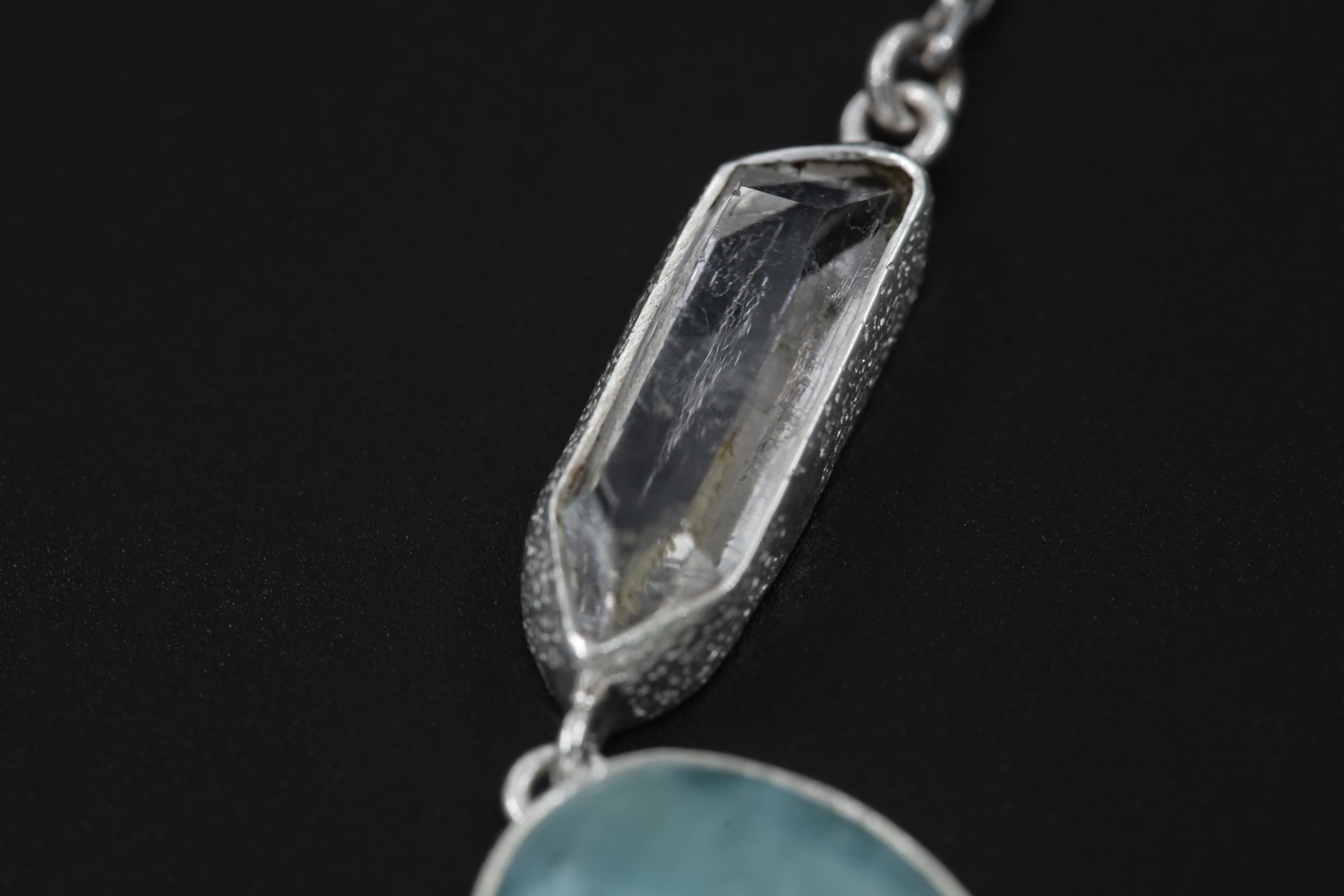 Close-up of Double-Terminated Clear Quartz point in a high-shine sterling silver Ocean’s Whisper necklace setting.