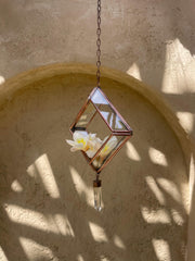 Copper Quartz rectangle ornament hanging in sunlight, with transparent glass panels and raw Clear Quartz crystal.