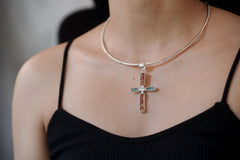 Celestial Harmony Cross pendant shown worn on the chest, with raw Red Kyanite, Apatite, Moonstone, and black cotton necklace.