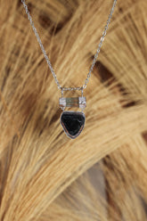 Aquamarine Watermelon Tourmaline pendant in organic 925 sterling silver shown on natural texture with cotton necklace.