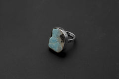 Freeform Larimar sterling silver ring shown on a dark background, with soft blue stone and polished bezel setting.