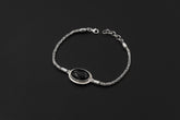 Black Onyx sterling silver Byzantine bracelet shown on dark background beside a ruler for adjustable length reference.