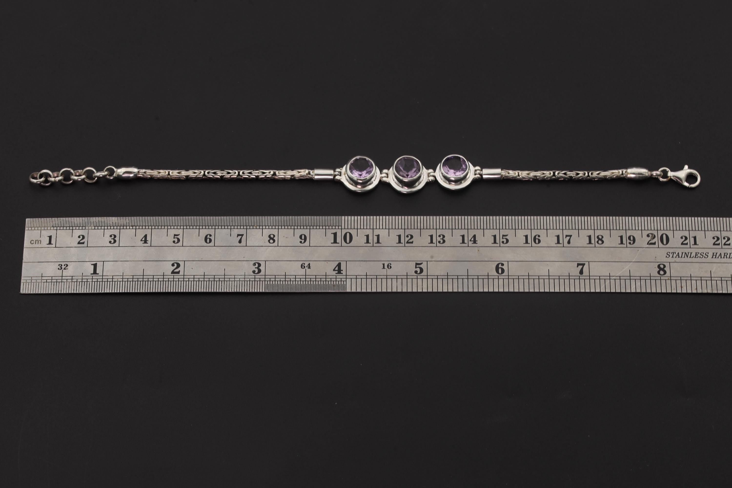 Amethyst sterling silver bracelet shown beside a ruler for adjustable 18 to 21 cm length reference.