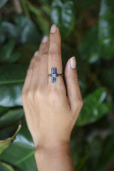 Handmade oxidized 925 sterling silver raw Kyanite ring shown worn on the hand, with deep indigo crystal and hammered band.