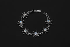 Celestial Blue Moonstone bracelet displayed on dark background with polished sterling silver starburst settings.