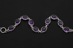 Close view of Amethyst bracelet showing smooth violet stones in polished sterling silver settings.