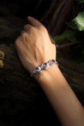 Amethyst Byzantine sterling silver bracelet shown worn on the wrist with three purple gemstones.
