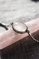 Rose Quartz sterling silver Byzantine bracelet shown on a dark background beside a ruler for adjustable length reference.