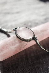 Rose Quartz sterling silver Byzantine bracelet shown on a dark background beside a ruler for adjustable length reference.