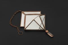 Quartz Reliquary hanging decoration shown on dark background with copper frame, mirrored glass, and Clear Quartz point.