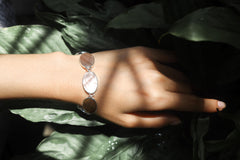 Mother of Pearl sterling silver bracelet shown worn on the wrist as a soft ocean-inspired shell bracelet.