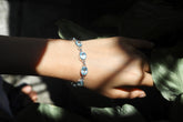 Blue Topaz sterling silver bracelet shown worn on the wrist with bright sky-blue faceted gemstones.