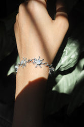 Blue Moonstone sterling silver starburst bracelet shown worn on the wrist with soft lunar gemstone flash.