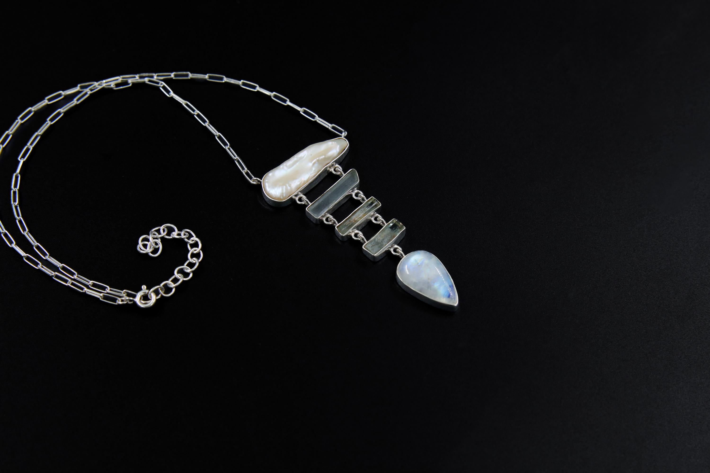 Raw Pearl Aquamarine Blue Moonstone necklace shown on a dark background with sterling silver wire link chain and aquatic pendant design.